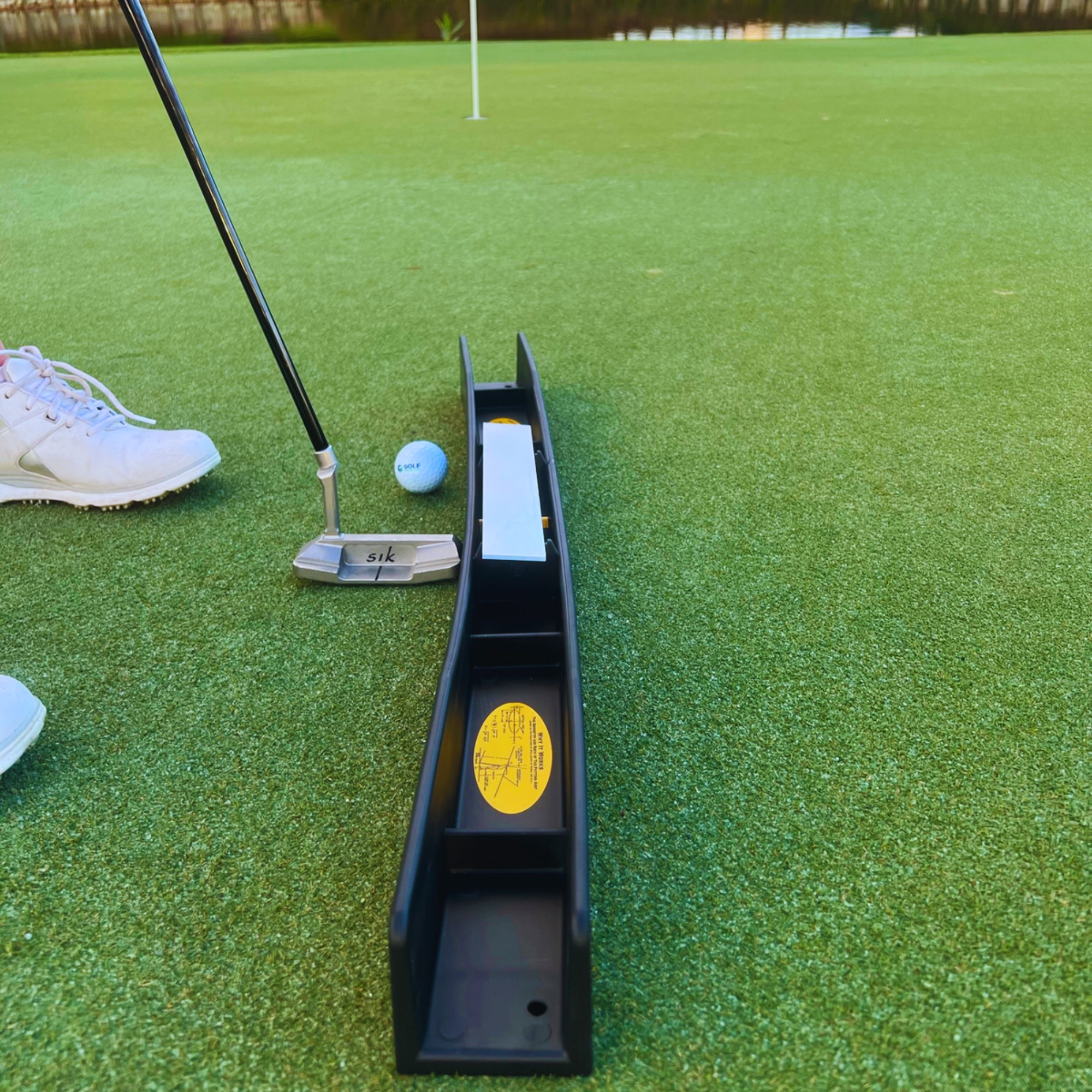 Putting Arc MS-3D training aid on a putting green with putter and golf ball at address