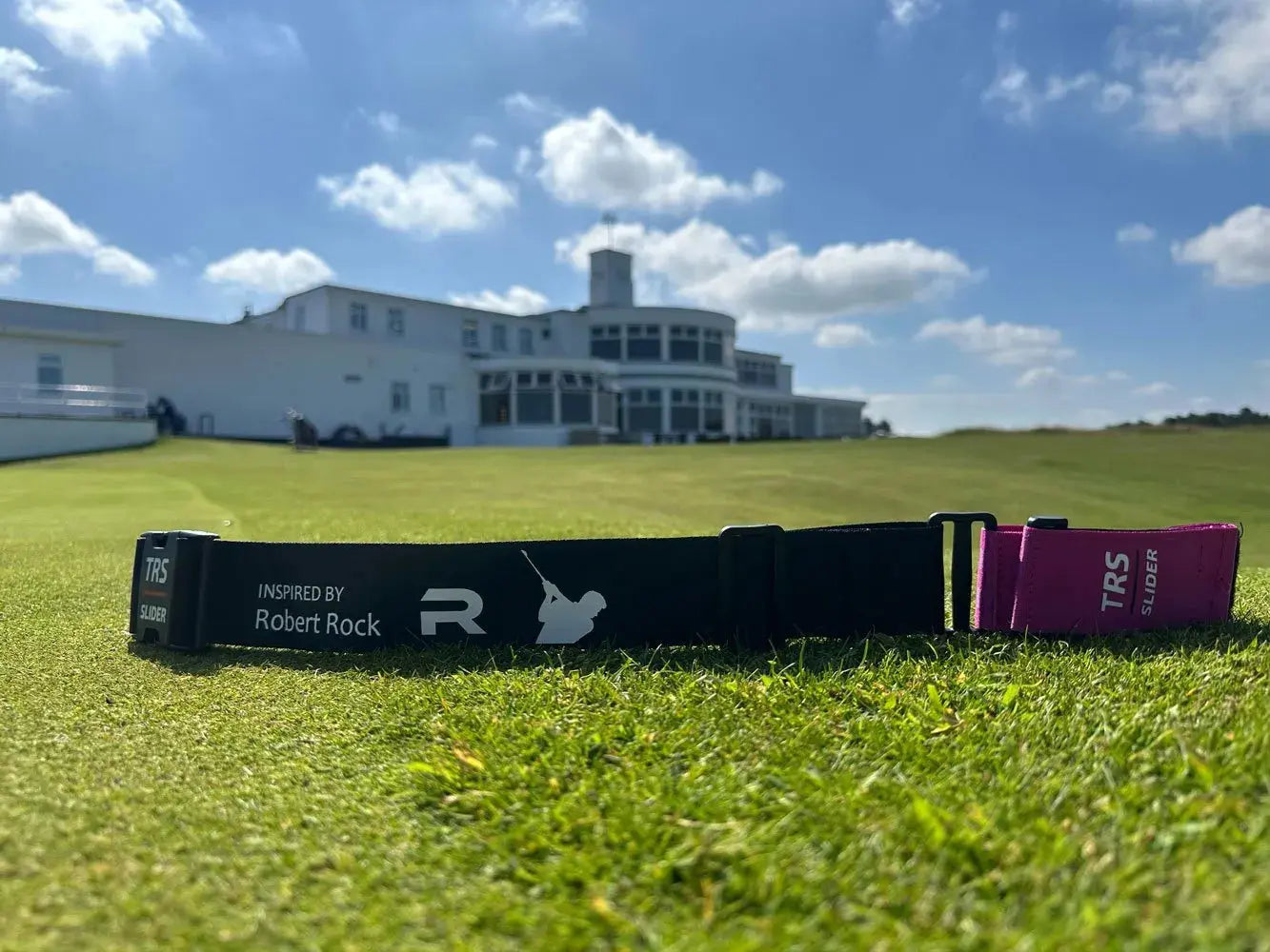 TRS Slider laying on golf course green with clubhouse behind