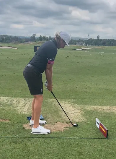 Golfer wearing TRS Slider during swing setup on driving range