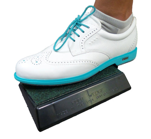Golf shoe positioned on the Foot Wedge balance training aid showing proper foot tilt angle