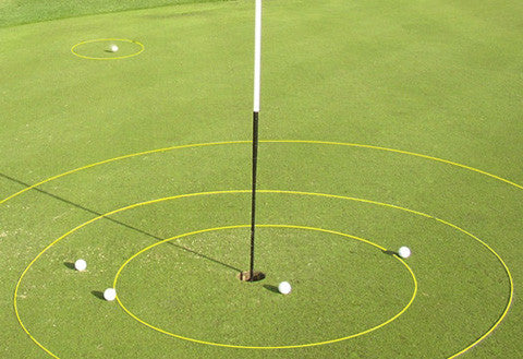 eGolfRing scoring rings arranged around a flag on a practice green with golf balls