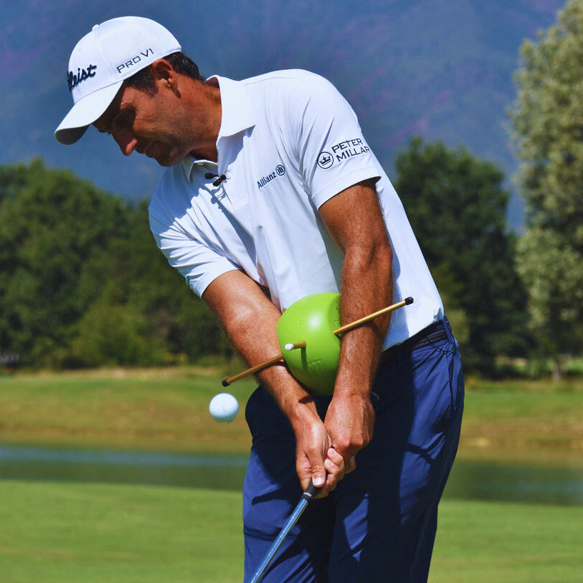 Golfer using The Connector training aid between arms and chest during a swing on the course